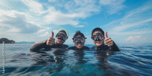 Three friends enjoying snorkeling adventure in tropical ocean waters during summer © Edvvin