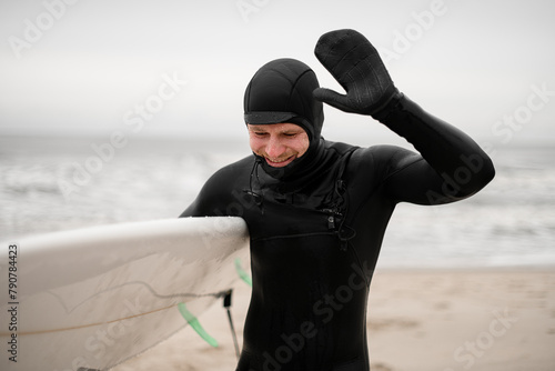 Happy smiling male surfer out of water, water drops visible on face