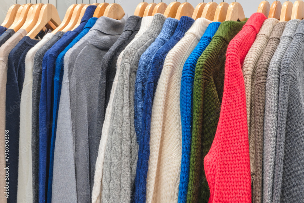 A rack of clothes with a variety of colors including blue, green, and red