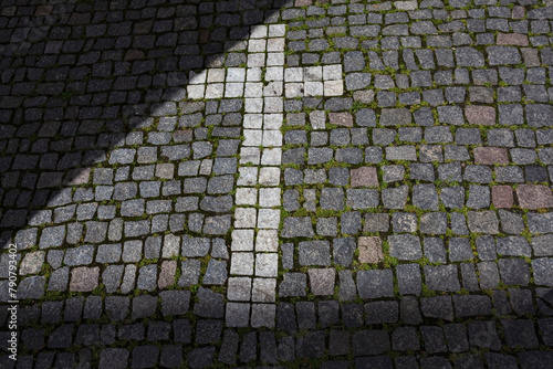 Paving stones laid out in the shape of a cross in front of one of the churches in Prague, Czech Republic 