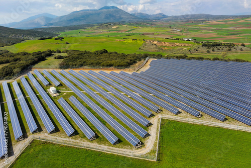 Rows of solar panels on the green meadow in Greece. Aerial view.