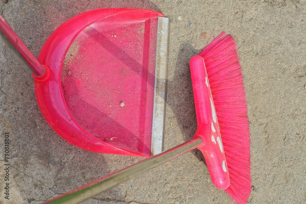 plastic pink modern dirty home dustpan with garbage and broom while cleaning on gray concrete floor outdoors plastic pink modern dirty home dustpan with garbage and broom while cleaning on gray concrete floor outdoors