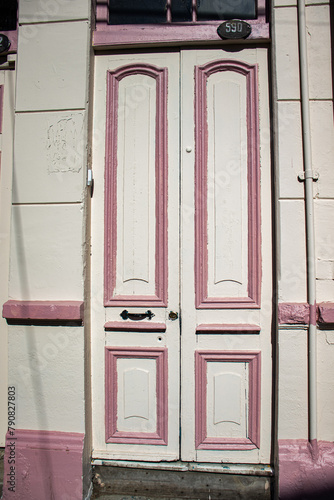 Foto de uma porta antiga em Valparaíso, Chile, com detalhes ornamentados e desgaste pelo tempo. Esta imagem de arquitetura urbana destaca a rica história da cidade costeira.