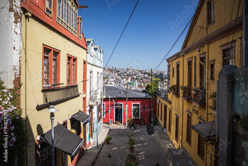 Casas e vielas de Valparaíso, Chile, em dia ensolarado de verão. A arquitetura colorida se destaca sob o céu azul, capturando a essência vibrante da cidade costeira.