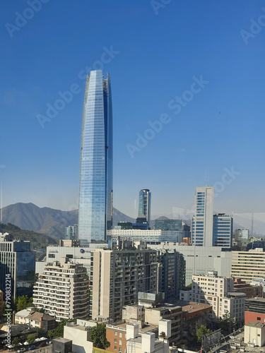 Vista da cidade de Santiago do Chile, a partir de um ponto de vista do alto, com o edifício Sky Costanera em primeiro plano e ao fundo os cerros e os Andes