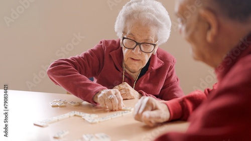 Senior people playing dominoes patiently in nursing home