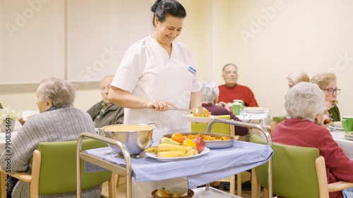 Friendly cook serving food to seniors in nursing home