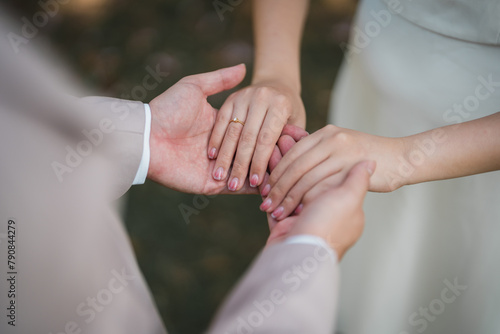 bride and groom holding hands with engagement diamond ring on the bride hand.