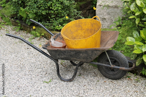 A Well Used Metal Gardening Wheelbarrow with Buckets.