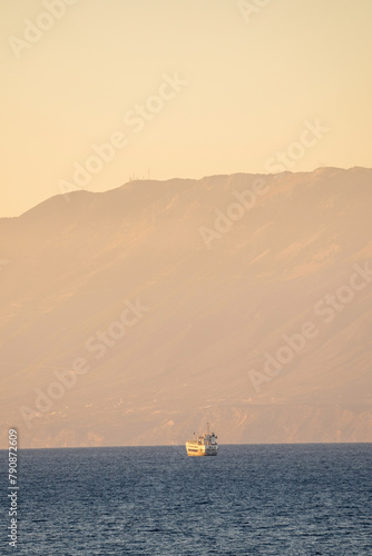 Obraz na płótnie A cruise ship sailing in the sea against mountain during sunrise in the place called Drosia in ths island of zakynthos in Greece w salonie