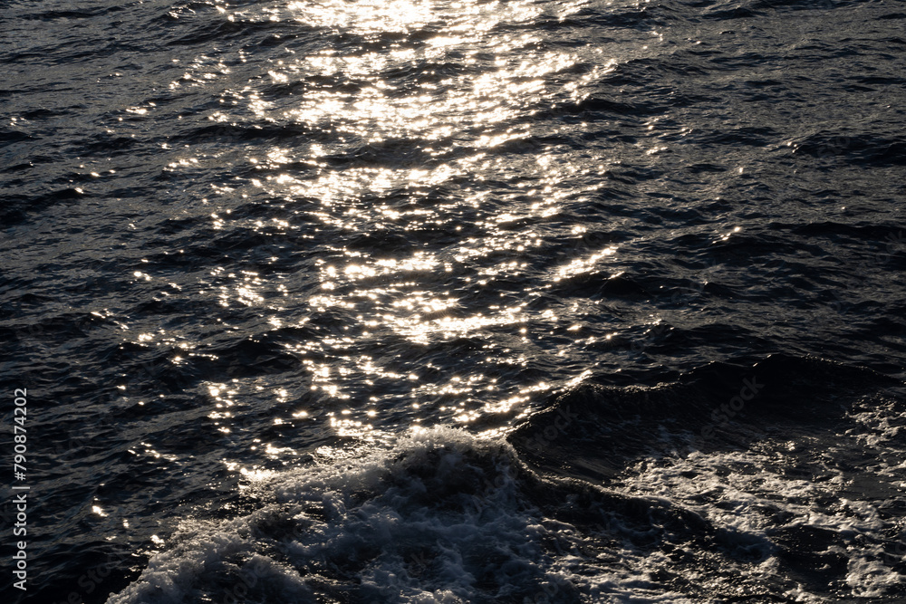 Lens star formed on water body on a sea, A calm ocean reflects sun stars in the morning light and foamy water along with waves