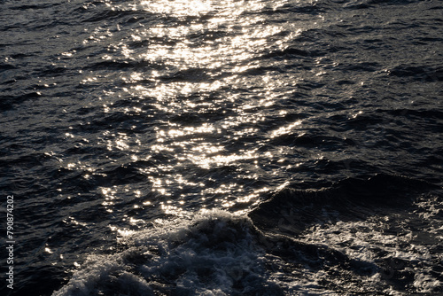 Obraz na płótnie Lens star formed on water body on a sea, A calm ocean reflects sun stars in the morning light and foamy water along with waves w salonie