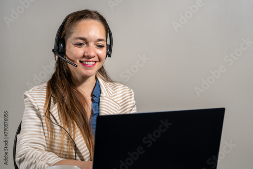 Mujer oficinista en una telellamada usando su laptop. photo