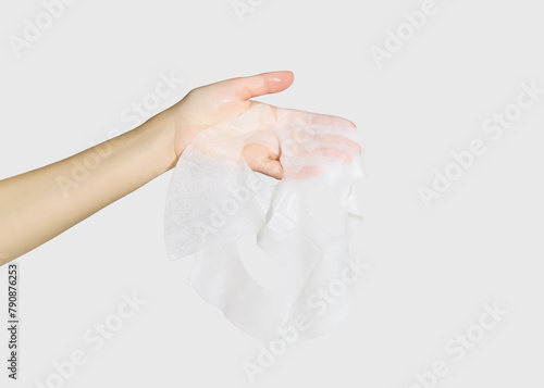hand holding fabric moisturising face mask isolated on white background