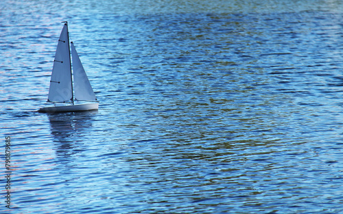 A Small Radio Controlled Sailing Boat on a Lake.