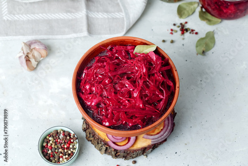 Fermented vegetables cabbage with carrot and beetroot in clay bowl, grey background. Flat Lay.
