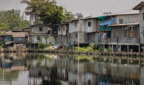In slum area, the houses are old along the Khlong Phra Khanong. Broken houses are beside the Canal with dirty water. Bad pollution problem, Space for text, Selective focus.
