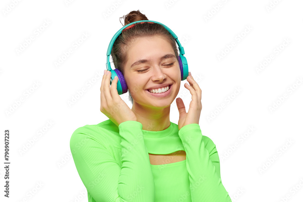 Happy smiling girl in neon green long sleeve top, listening to favorite music in wireless headphones Happy smiling girl in neon green long sleeve top, listening to favorite music in wireless headphones
