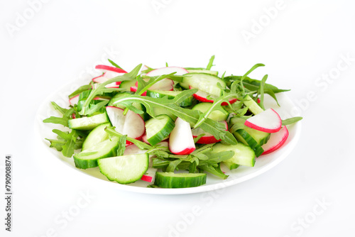 a plate of radish, cucumber and arugula close up 