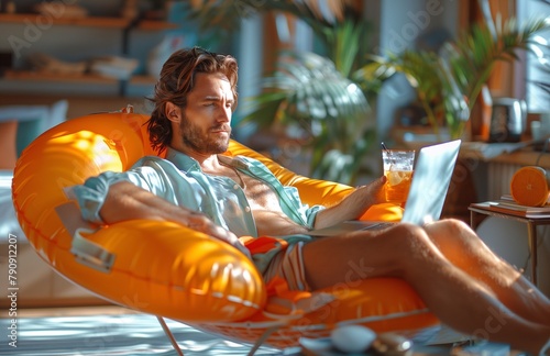 Professional relaxing by beach, laptop in hand, with swim rings and inflatable pool nearby