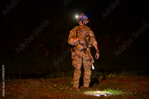 Soldiers in camouflage uniforms aiming with their rifles.ready to fire during Military Operation at night, soldiers training  in a military operation