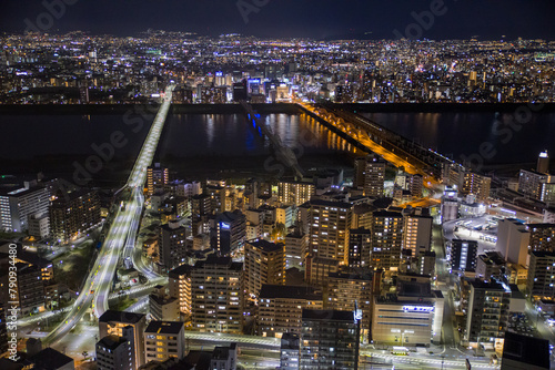 View of the Osaka skyline at night with the Yodo river and bridges