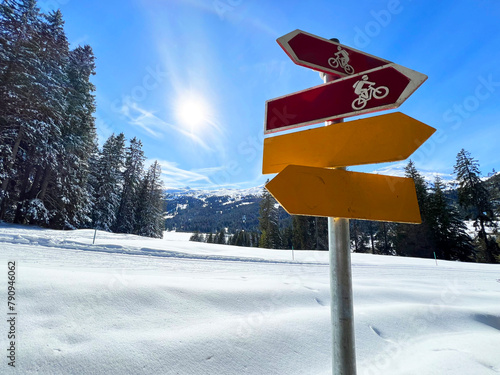 Hiking markings and orientation signs with signposts for navigating in the idyllic winter ambience above the tourist resorts of Valbella and Lenzerheide in Swiss Alps - Canton of Grisons, Switzerland