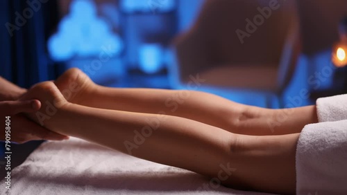 Masseuse makes an anticellulite relaxing foot massage in a spa for a young girl in a comfortable atmosphere with evening light. Therapeutic foot massage, recovery after injuries, health maintenance. photo