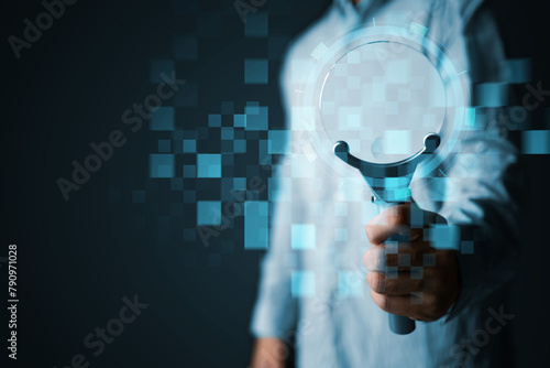 Businessman holding a magnifying glass for research in business data analysis, and development for growth to reach big data tech company target goals. Dark blue copyspace background.
