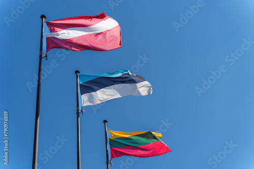 The flags of the three Baltic countries, Lithuania, Latvia and Estonia flutter against a clear blue sky photo