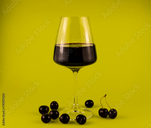 A glass of red wine with cherries