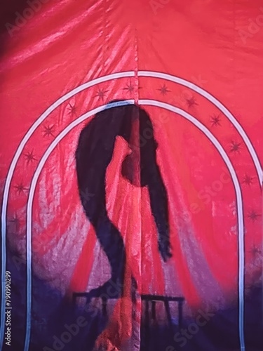 Circus acrobat silhouette showcasing astonishing contortion and  balancing act on the table amidst dazzling performance isolated in the  vibrant red background filled with stars and a white base.