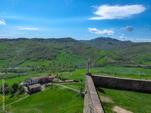 Scenic view from Medieval towns and castles of Emilia Romagna, Italy, Europe. Castel Arquato town and Rocca Viscontea castle on hill surrounded by greenery. Tranquil and calm scenery. Clear blue sky photo