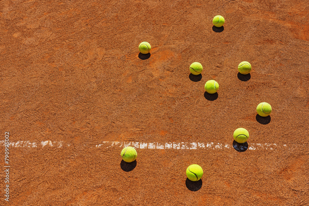  A yellow tennis balls lies on the clay court. Big panorama.