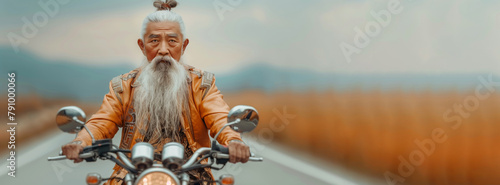 A Chinese man with a long beard is riding a motorcycle down a road. The man is wearing a leather jacket and he is enjoying the ride. chinese kung fu master, white hair tied in a bun, a lwhite goatee.