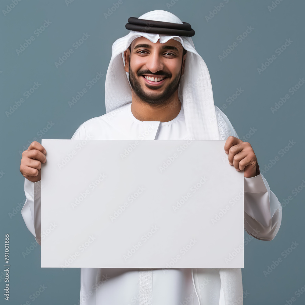 Smiling man in traditional arab attire holding blank sign Smiling man in traditional arab attire holding blank sign