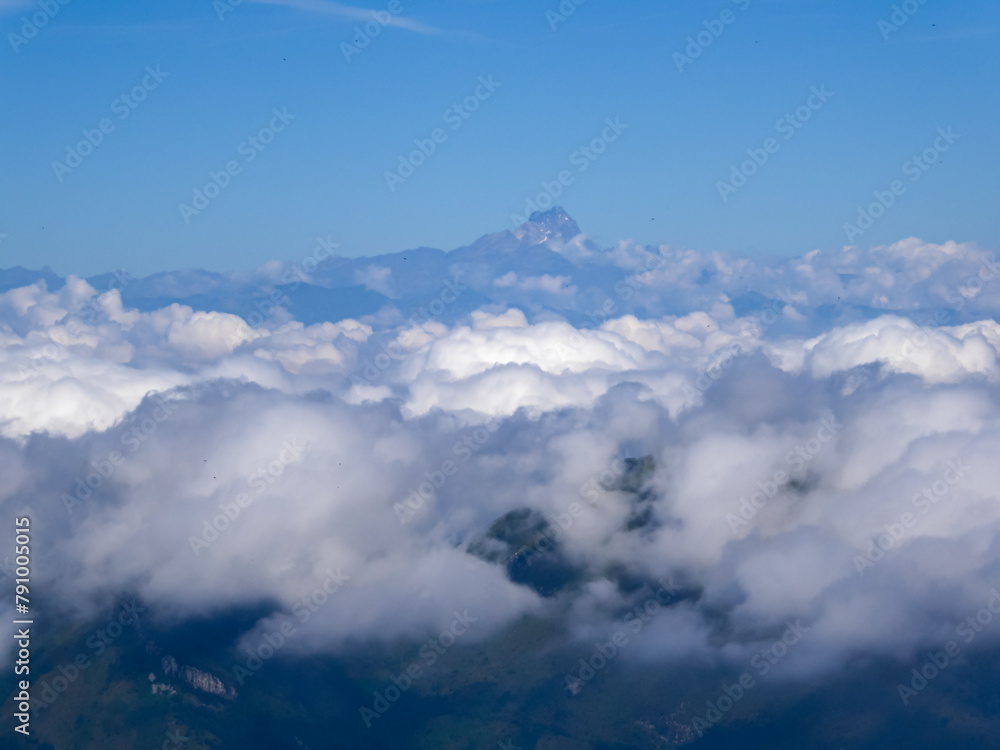 Scenic view of mountain range covered by clouds seen from scenic mtb trail along ancient pathway from Alps to sea, through Italian regions of Piemonte and Liguria, and France. Monte Viso in distance
