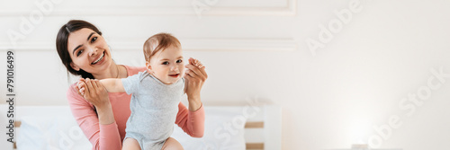 Photos Happy mom helping to her infant child making first steps