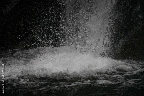 Closeup of waterfall, white water splashing on a black background, Tbilisi, Georgia, botanical garden
