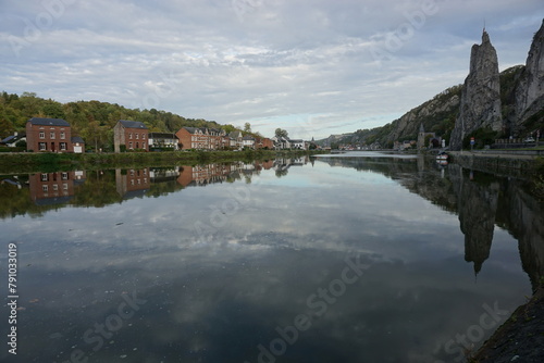 view of the town of Dinant in Belgium on the Meuse river with the sheer cliffs and mirror reflection  © poupine