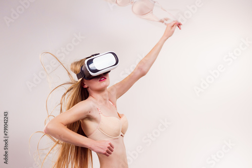 Girl in virtual reality goggles holds bra