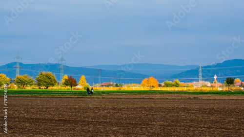 Sunlit autumn landscape with arable and blue hills