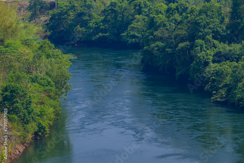 An aerial view of the dam-caused canal in Thailand's national park, with a mountain the background. Bird eye view.