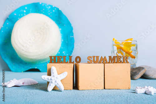 Concept hello summer text on cubes on a background of cocktail, hat and starfish