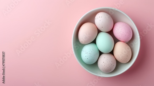   A white bowl holds pastel-hued eggs against a light pink backdrop, subtly speckled