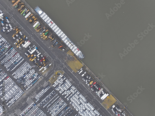 Aerial top down view on roll on roll off terminal, shipping and logistics of vehicles over the world. Top down view on ship docked and loaded in the port. Zeebrugge, Belgium.