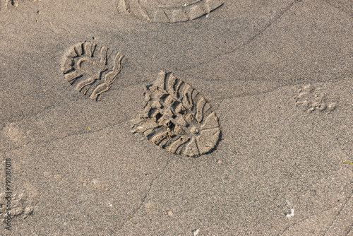 Fussabdruck eines Stiefels mit Profil im Sand