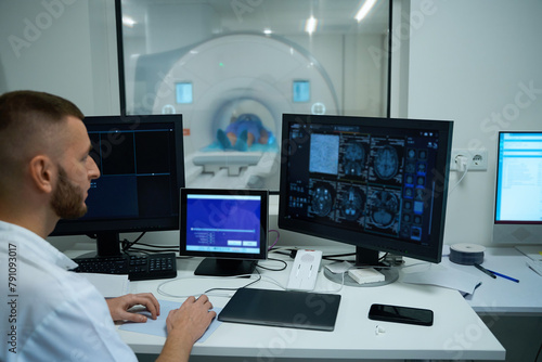Technologist conducting head MRI on adult person