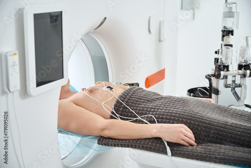 Photos Man undergoing contrast-enhanced ECG-gated coronary CT angiography procedure