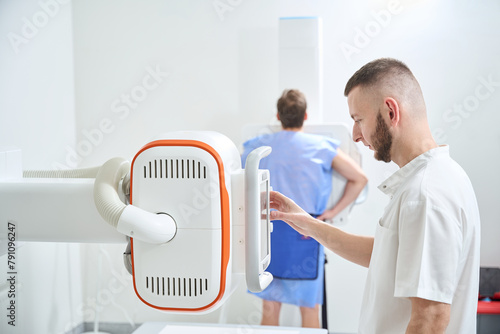 Radiologic technologist is preparing patient for digital chest radiography